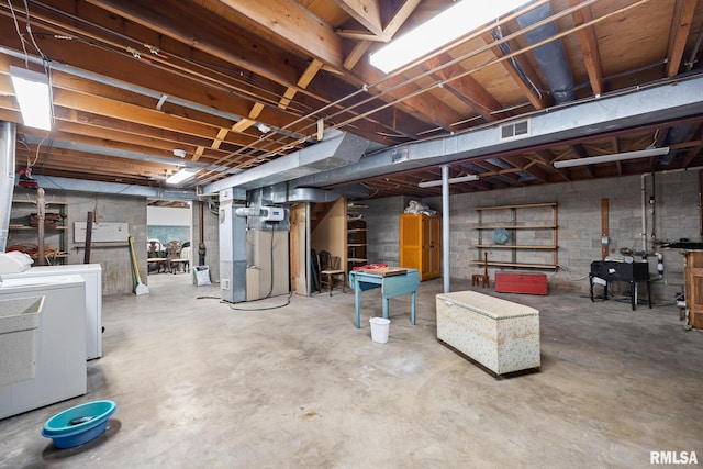 basement with heating unit and washing machine and clothes dryer