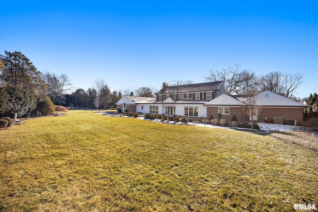 rear view of house featuring a yard