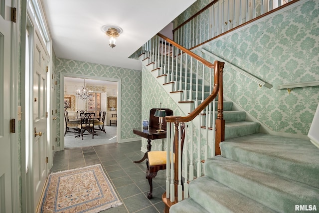 stairs featuring tile patterned floors and a notable chandelier