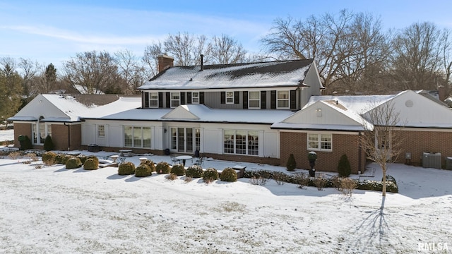 snow covered property with central air condition unit