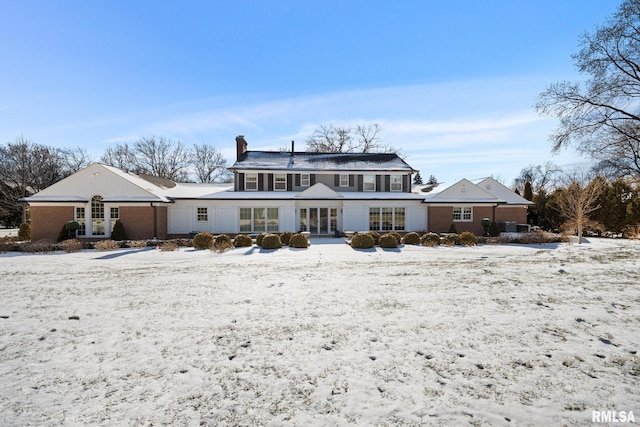 view of snow covered back of property