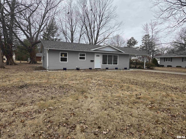 ranch-style house with a carport and a front lawn