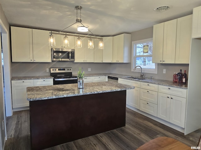 104 Parkway Dr, Carthage, IL 62321 - kitchen with stainless steel appliances, a sink, a center island, white cabinetry, and dark wood-style flooring