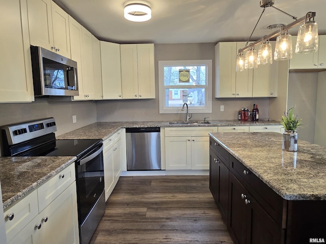 104 Parkway Dr, Carthage, IL 62321 - kitchen with appliances with stainless steel finishes, a sink, white cabinetry, light stone counters, and dark wood finished floors