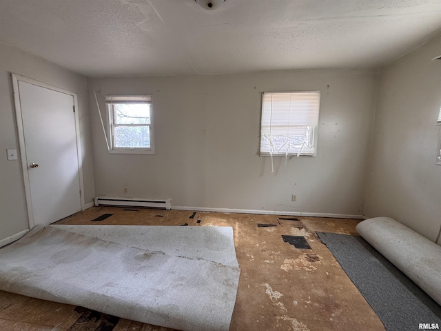 unfurnished room featuring a baseboard radiator and a textured ceiling