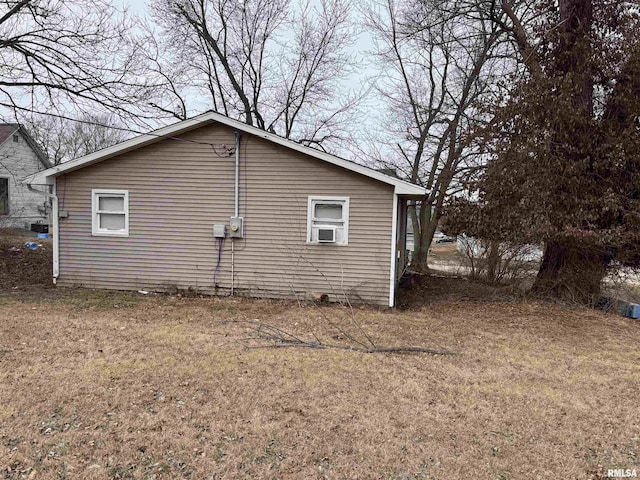 view of side of property with cooling unit and a yard