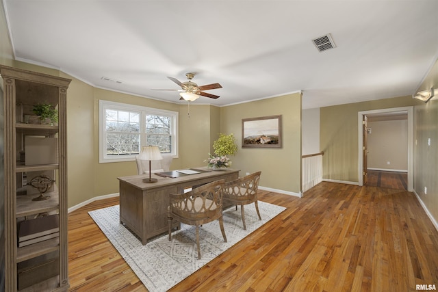 home office with crown molding, light hardwood / wood-style floors, and ceiling fan