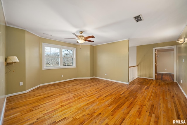 spare room with crown molding, ceiling fan, and light hardwood / wood-style flooring