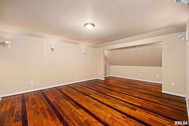 additional living space featuring lofted ceiling and dark hardwood / wood-style floors