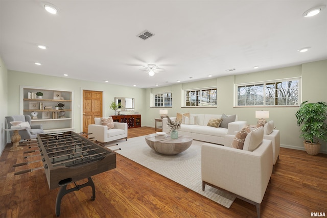 living room with plenty of natural light, dark hardwood / wood-style floors, and ceiling fan