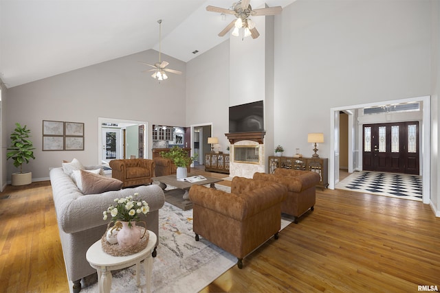 living room featuring wood-type flooring, high vaulted ceiling, and ceiling fan