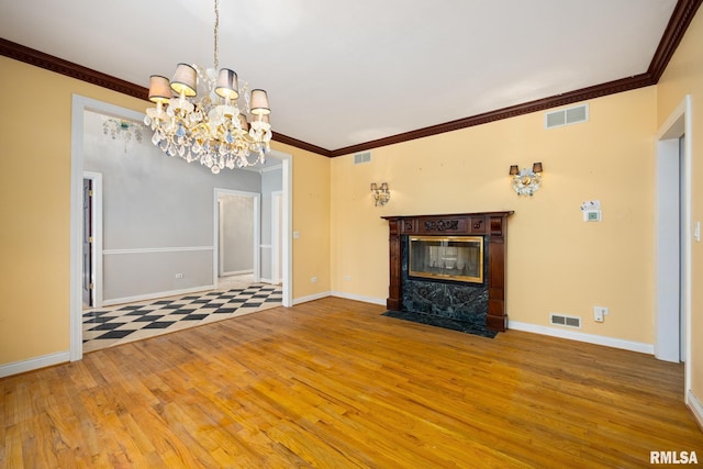 unfurnished living room featuring a notable chandelier, hardwood / wood-style flooring, and ornamental molding