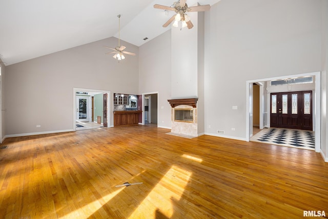 unfurnished living room featuring high vaulted ceiling, hardwood / wood-style floors, and ceiling fan