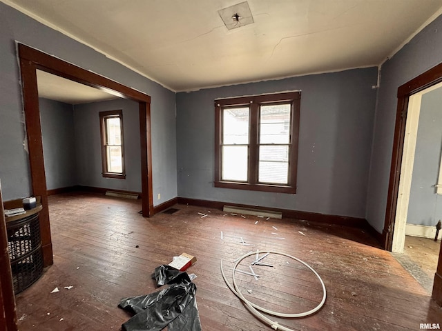 unfurnished room with dark wood-type flooring and a baseboard radiator