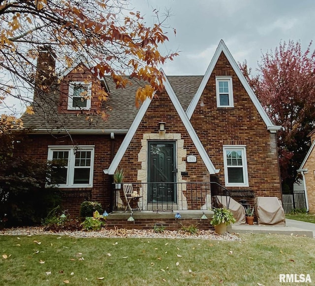 english style home with a front lawn