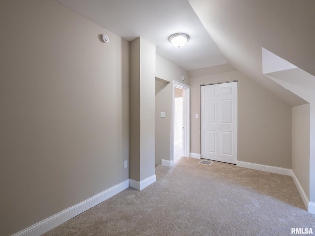 additional living space with light carpet and lofted ceiling