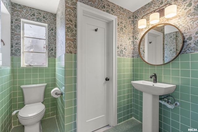 bathroom with tile walls, sink, and toilet