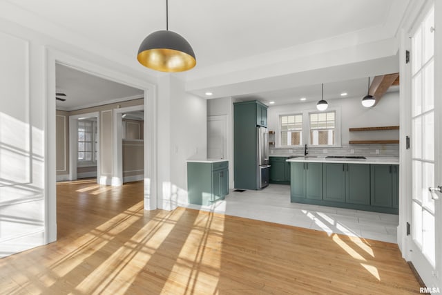 kitchen featuring pendant lighting, backsplash, green cabinetry, high end refrigerator, and light wood-type flooring