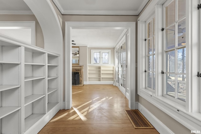 hall with crown molding and light hardwood / wood-style flooring