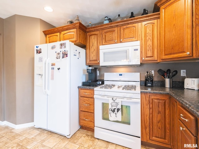 kitchen with white appliances and dark stone countertops