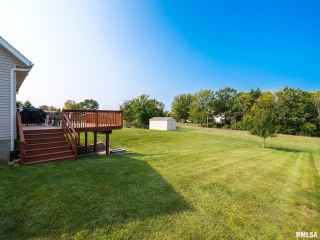 view of yard featuring a deck and a shed