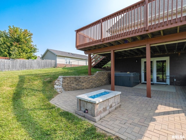 view of patio / terrace featuring a wooden deck, an outdoor fire pit, and a hot tub