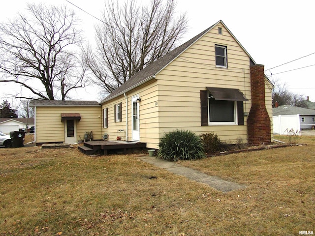 rear view of house featuring a wooden deck and a yard