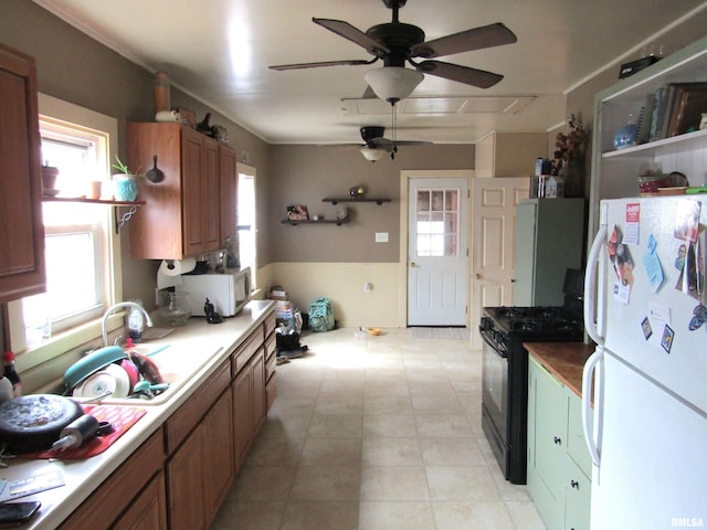 kitchen with ceiling fan, white appliances, plenty of natural light, and sink