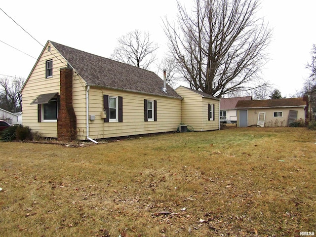 rear view of house featuring a yard