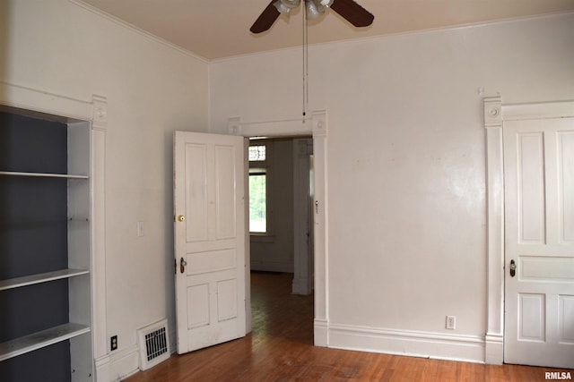 unfurnished bedroom featuring dark wood-type flooring, ceiling fan, and ornamental molding