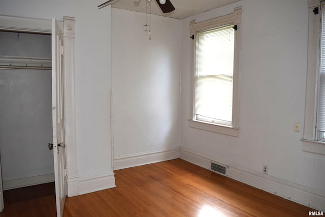 unfurnished bedroom featuring multiple windows, a closet, ceiling fan, and light wood-type flooring