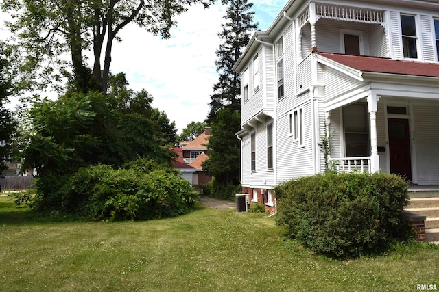 view of side of home with a lawn and central air condition unit