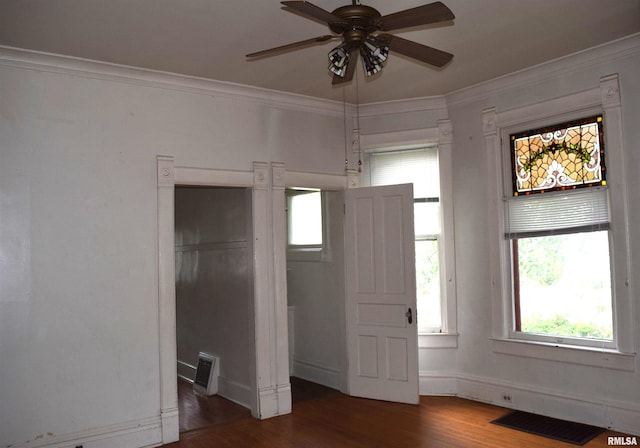 unfurnished bedroom with dark hardwood / wood-style flooring, ornamental molding, and ceiling fan