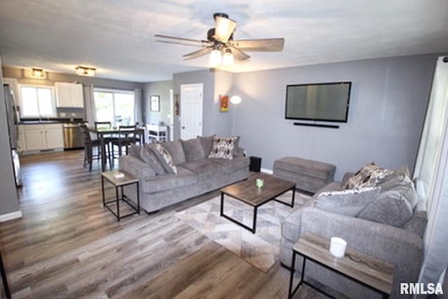 living room featuring ceiling fan and light hardwood / wood-style floors