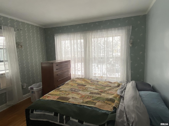 bedroom with crown molding, multiple windows, and hardwood / wood-style flooring