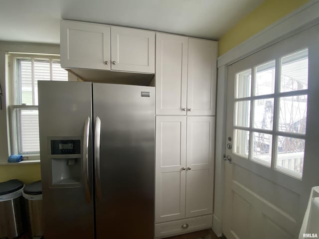 kitchen featuring white cabinets and stainless steel refrigerator with ice dispenser