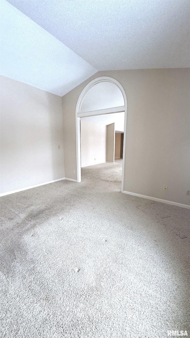 carpeted spare room with a textured ceiling and baseboards