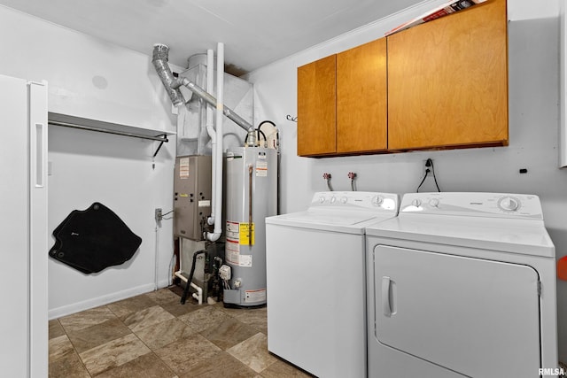 laundry area with cabinets, washing machine and dryer, and gas water heater