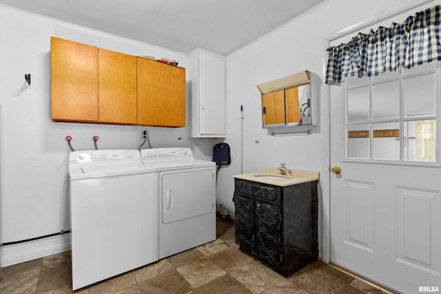 laundry room featuring cabinets, crown molding, washer and dryer, and sink