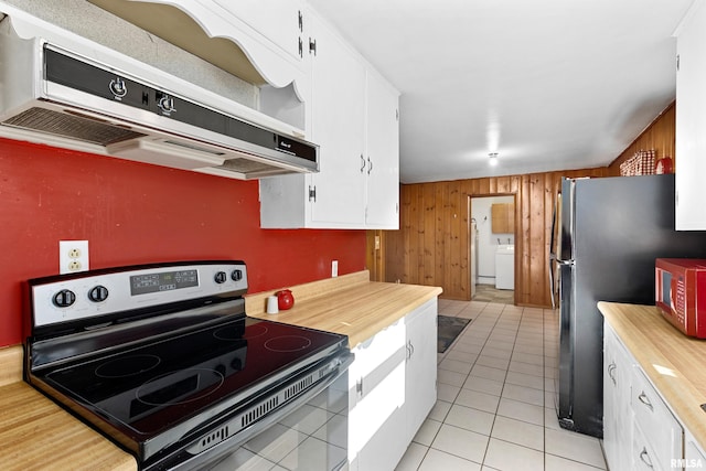 kitchen with extractor fan, white cabinetry, wooden walls, stainless steel appliances, and washer / clothes dryer