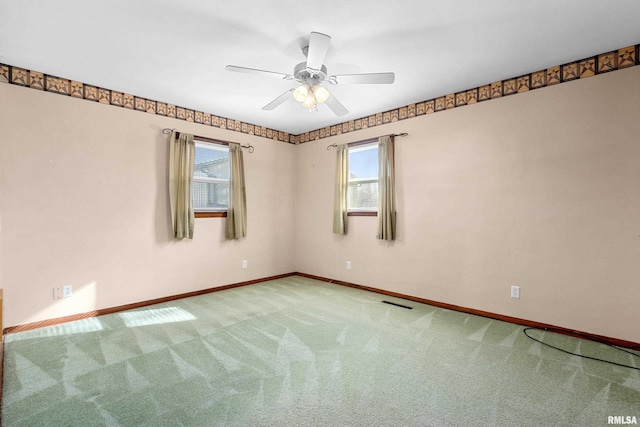 carpeted spare room with ceiling fan