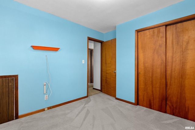 unfurnished bedroom featuring light colored carpet and a closet