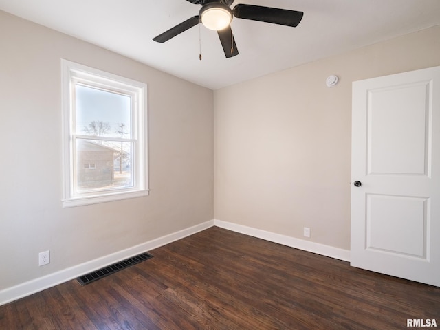 spare room with dark wood-type flooring and ceiling fan