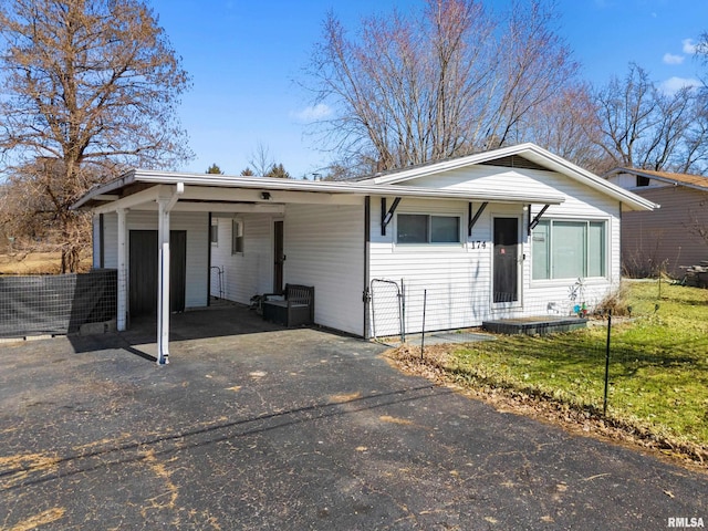 view of front of house with driveway, fence, and a carport