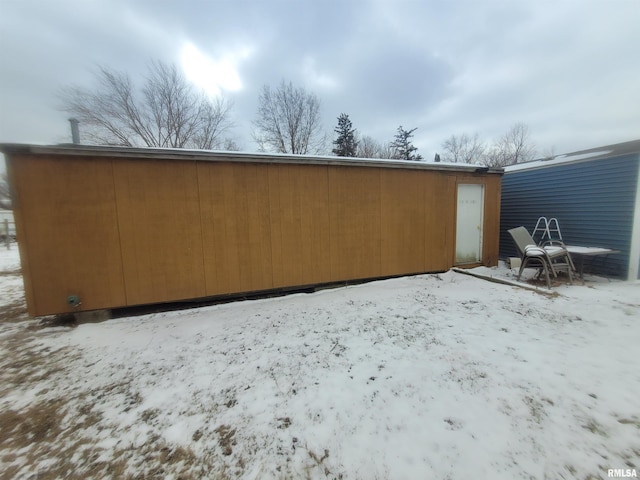 view of snow covered back of property