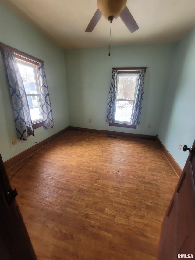 empty room featuring hardwood / wood-style floors, a wealth of natural light, and ceiling fan