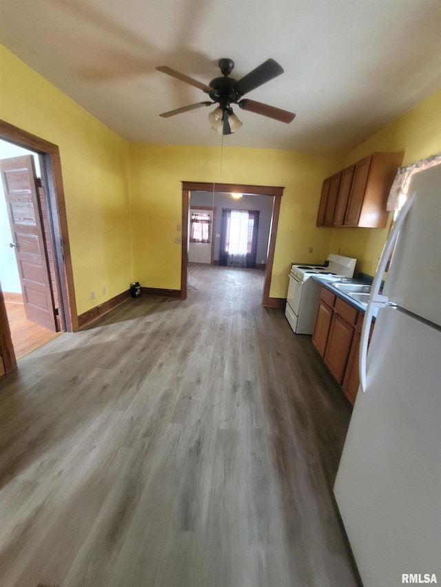 kitchen with ceiling fan, white appliances, and light hardwood / wood-style flooring