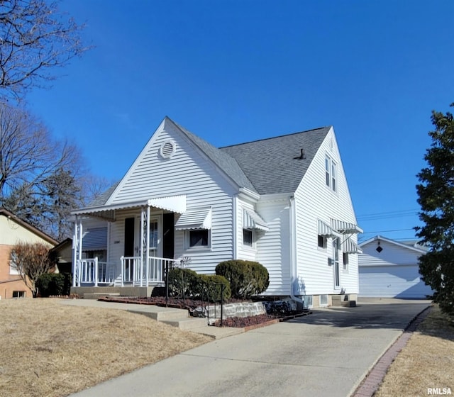 view of front of house featuring a garage, covered porch, an outdoor structure, and roof with shingles