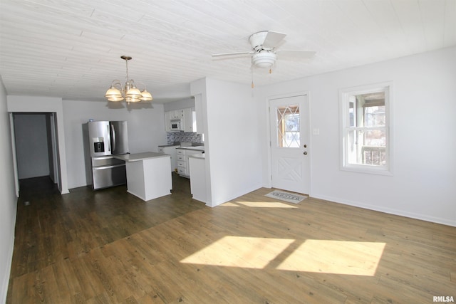 kitchen featuring stainless steel refrigerator with ice dispenser, tasteful backsplash, dark wood-type flooring, white cabinets, and pendant lighting