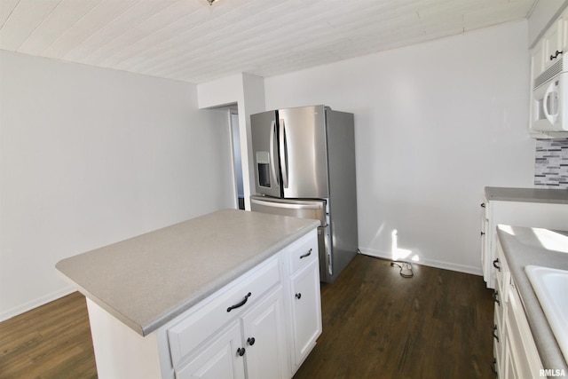 kitchen featuring backsplash, stainless steel refrigerator with ice dispenser, a center island, white cabinetry, and dark hardwood / wood-style floors